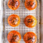 overhead shot of six burger buns on a baking tray