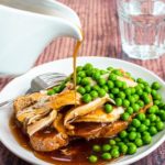 Gravy pouring on hot turkey sandwich with peas