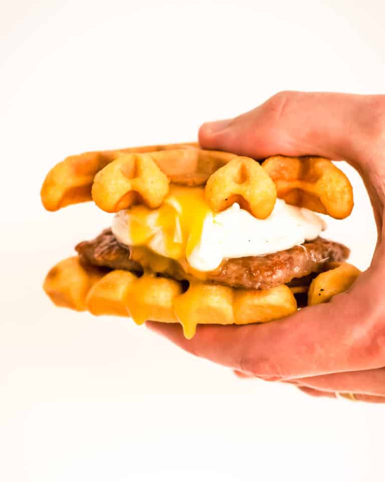 southern cornmeal waffles sandwich with poached egg and sausage patty