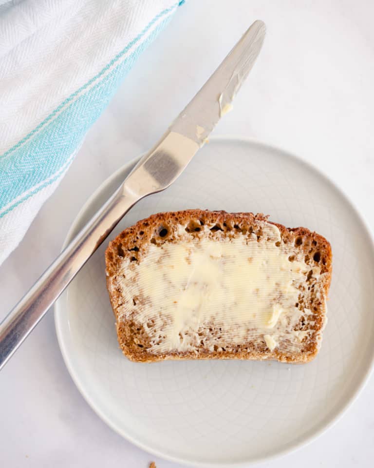 top down picture of oatmeal molasses bread spread with butter