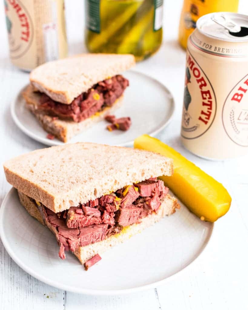 Montreal smoked meat piled high on rye bread with yellow mustard and dill pickles