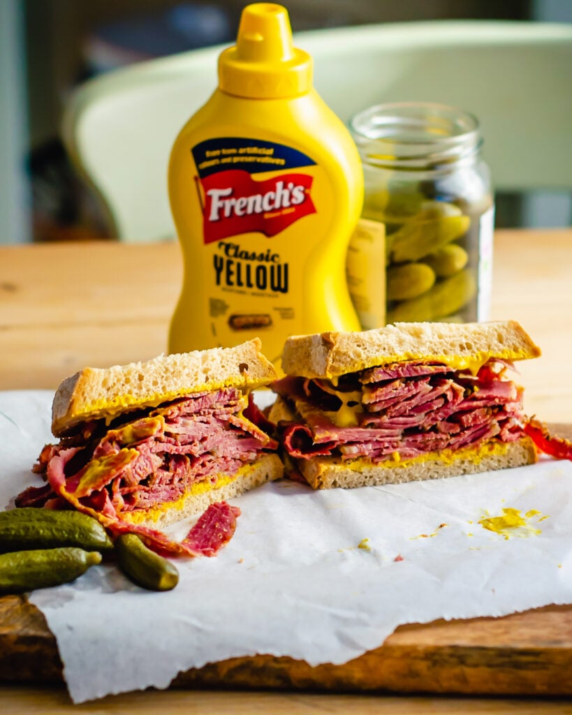 Close-up of sliced Montreal smoked meat on rye bread with mustard